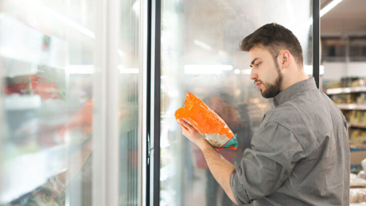 Uomo che esamina l’etichetta di un alimento al supermercato per comprendere la quantità di zucchero presente 
